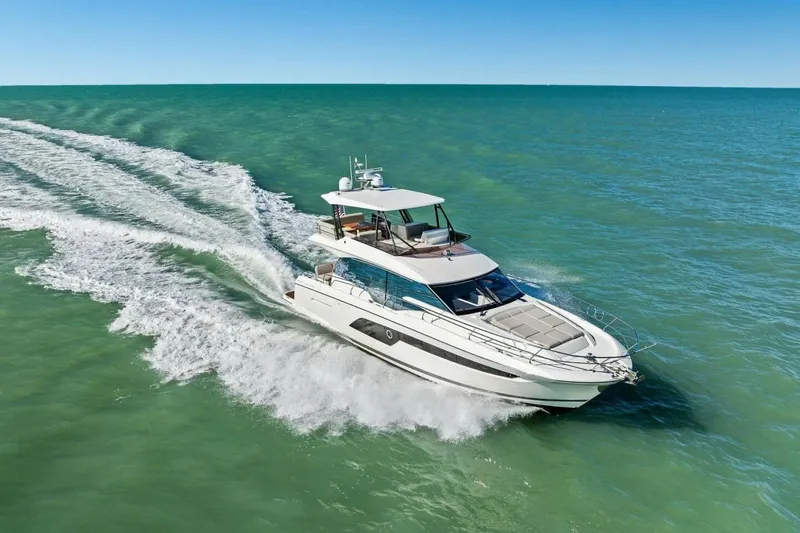 Slide: The Image of Luxury 2022 Prestige 520 yacht cruising on open sea under clear blue sky. - 91