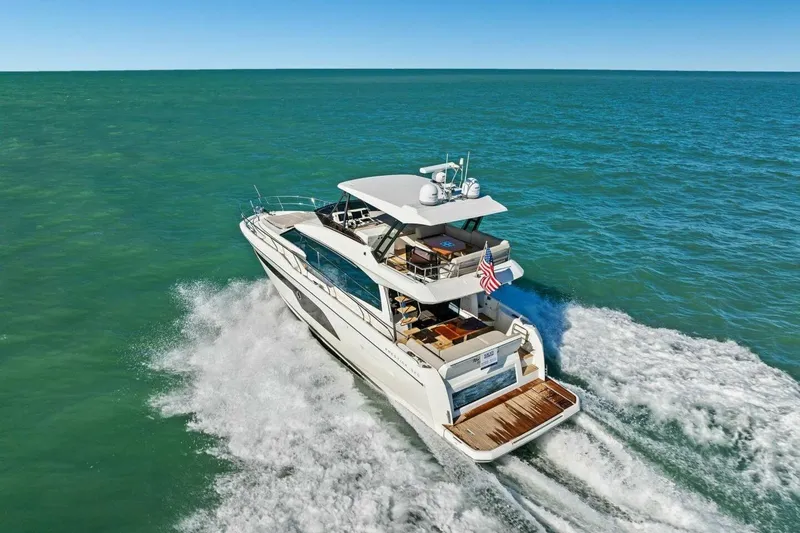 Slide: The Image of 2022 Prestige 520 yacht cruising on open sea, rear view. - 95