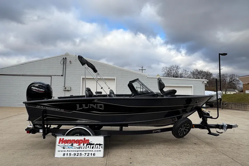 The Image of 2026 Lund 1875 Crossover XS boat on trailer, displayed outdoors at Hennepin Marine. - 0