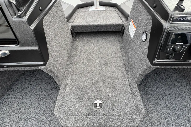Slide: The Image of Interior view of 2026 Lund 1875 Crossover XS boat, featuring carpeted flooring and control panel. - 16