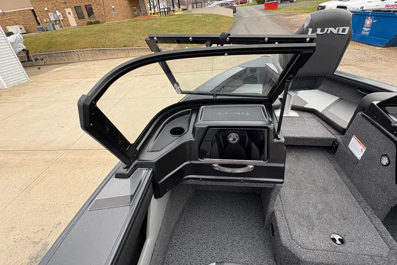 Slide: The Image of 2026 Lund 1875 Crossover XS boat interior with open windshield and seating. - 19