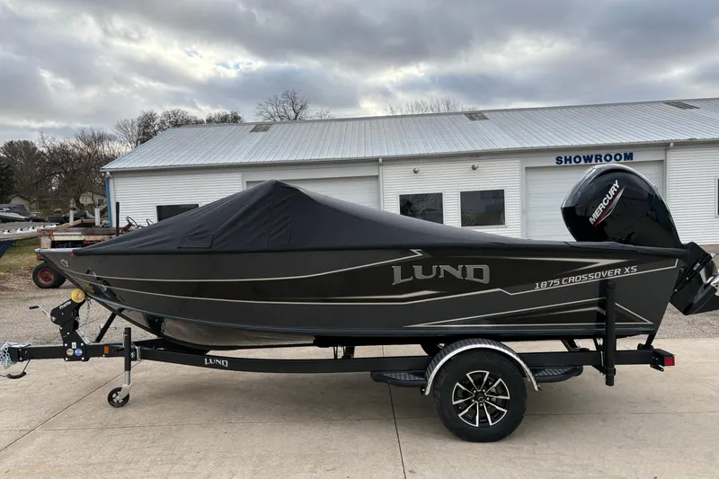 Slide: The Image of 2026 Lund 1875 Crossover XS boat on trailer, covered, outside showroom. - 31