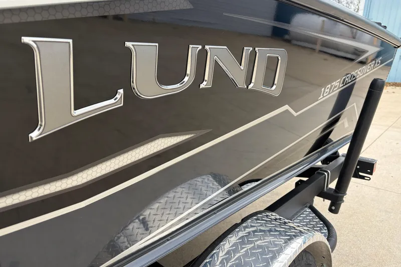 Slide: The Image of 2026 Lund 1875 Crossover XS boat side view with logo and trailer. - 8