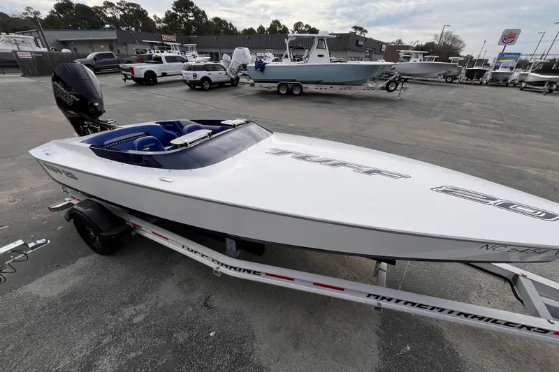 Slide: The Image of 2023 Tuff 20 speedboat on trailer in parking lot, surrounded by vehicles and boats. - 10