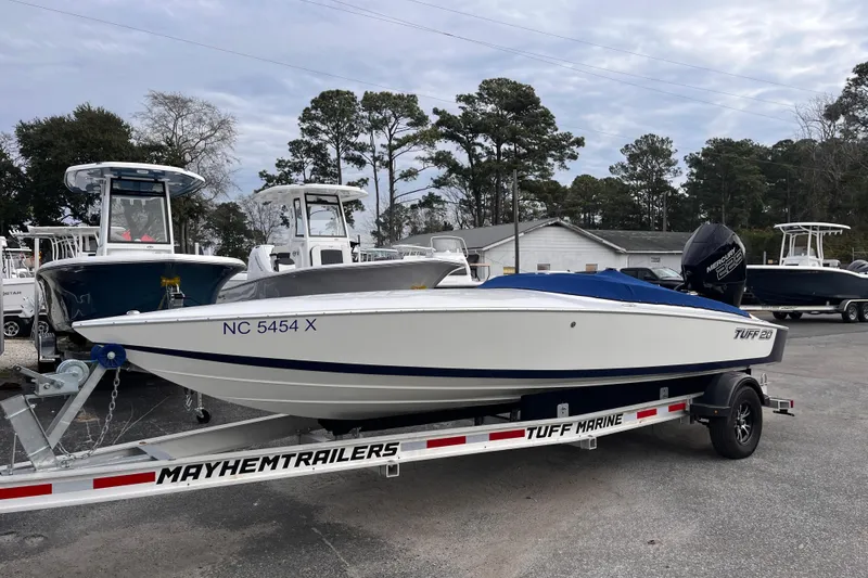 Slide: The Image of 2023 Tuff 20 boat on trailer, parked outdoors with other boats. - 3
