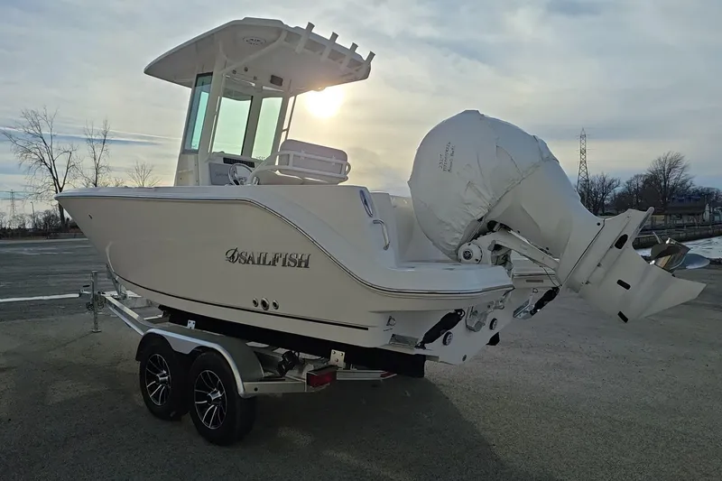 Slide: The Image of 2026 Sailfish 232 CC boat on trailer, parked outdoors at sunset. - 2
