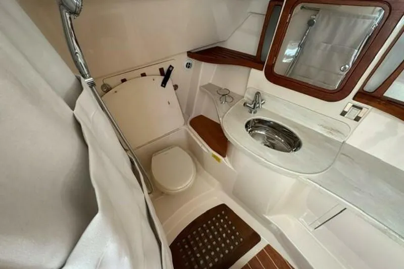Slide: The Image of 2025 Grady-White Freedom 375 boat bathroom with sink, toilet, and wooden accents. - 10