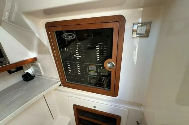 Slide: The Image of Electrical panel inside 2025 Grady-White Freedom 375 boat, featuring wooden trim and modern design. - 11