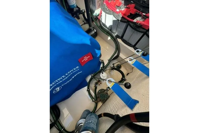 Slide: The Image of Engine compartment of 2025 Grady-White Freedom 375 boat with protective cover and wiring. - 13