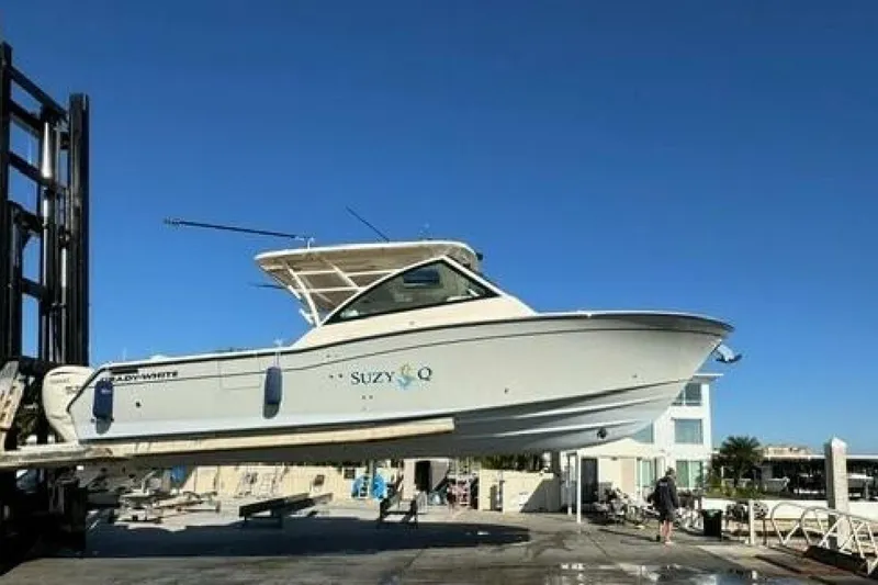 Slide: The Image of 2025 Grady-White Freedom 375 boat lifted at marina under clear blue sky. - 16