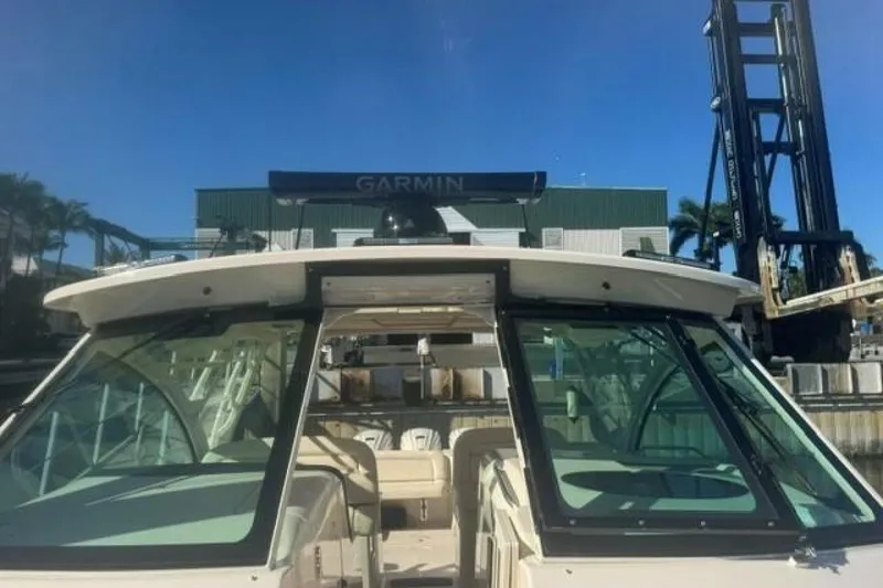 Slide: The Image of 2025 Grady-White Freedom 375 boat docked, featuring Garmin equipment, under clear blue sky. - 5