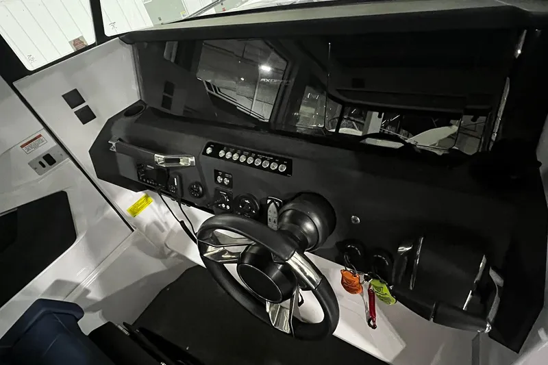 Slide: The Image of 2025 Axopar 29 XC Cross Cabin dashboard with steering wheel and control panel. - 10