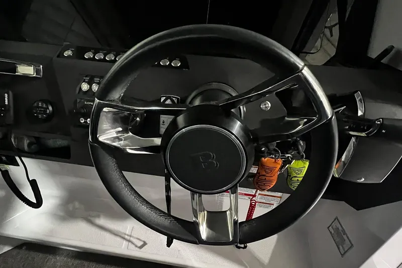 Slide: The Image of Steering wheel of 2025 Axopar 29 XC Cross Cabin boat, featuring modern controls. - 12