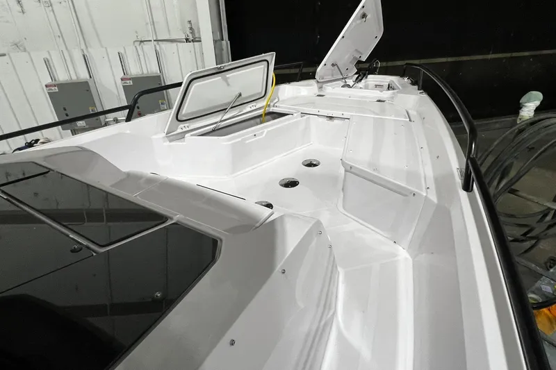 Slide: The Image of 2025 Axopar 29 XC Cross Cabin boat deck with open storage compartments. - 2