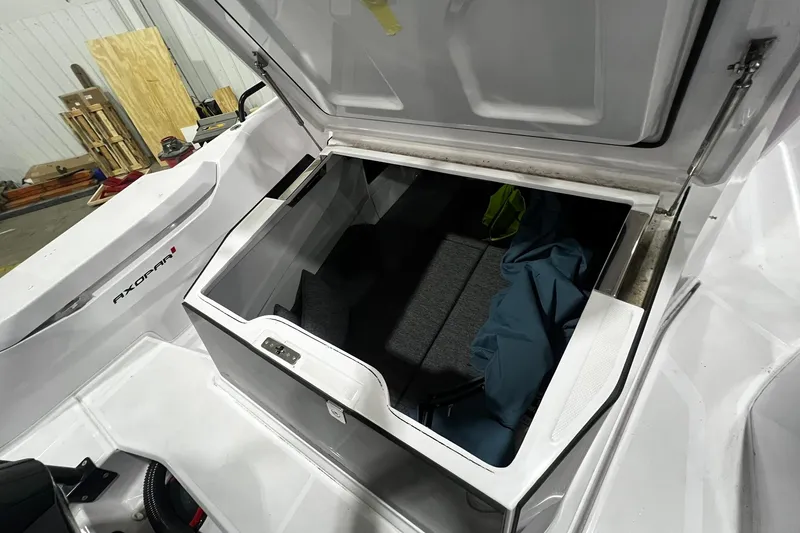 Slide: The Image of 2025 Axopar 29 XC Cross Cabin storage compartment open, showcasing interior space. - 22