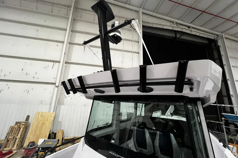 Slide: The Image of 2025 Axopar 29 XC Cross Cabin boat in a warehouse, showcasing roof and equipment. - 24