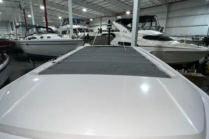 Slide: The Image of 2025 Axopar 29 XC Cross Cabin in a boat showroom, surrounded by other vessels. - 6