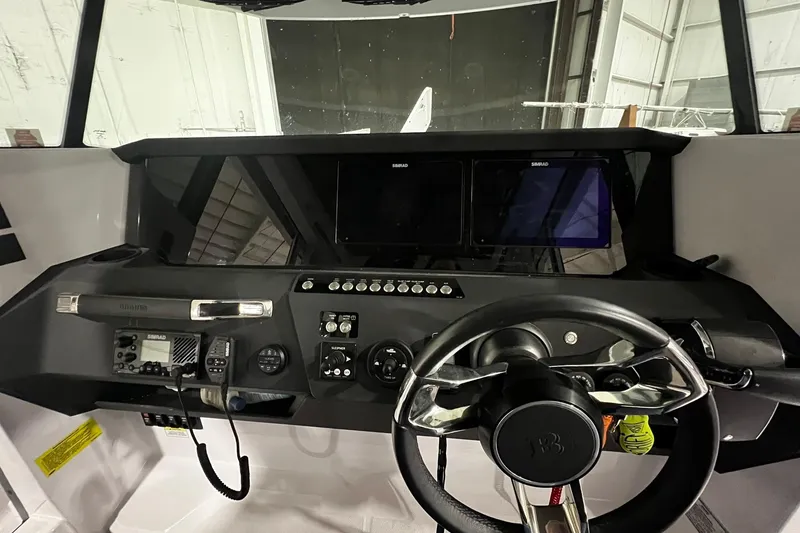 Slide: The Image of 2025 Axopar 29 XC Cross Cabin dashboard with steering wheel and navigation controls. - 9