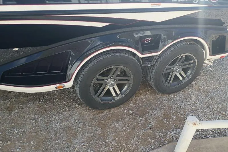 Slide: The Image of 2018 Ranger Z521L boat trailer with dual black wheels on gravel surface. - 3