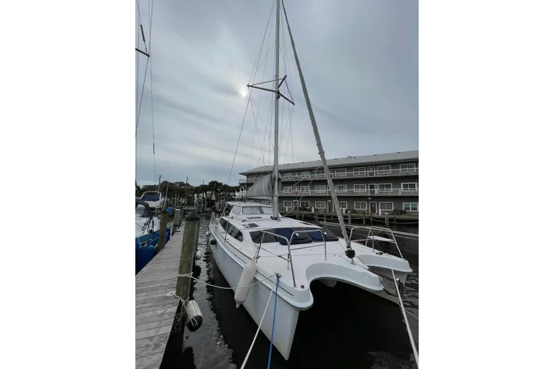 The Image of 2013 Gemini Legacy 35 catamaran docked at marina under cloudy sky. - 0