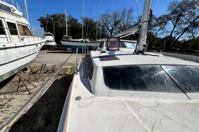 Slide: The Image of 2013 Gemini Legacy 35 sailboat on land, surrounded by other boats and trees. - 124