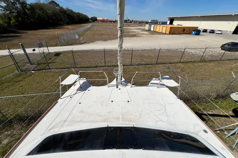 Slide: The Image of 2013 Gemini Legacy 35 catamaran on land, surrounded by fencing and industrial buildings. - 127