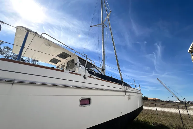 Slide: The Image of 2013 Gemini Legacy 35 sailboat under clear blue sky, docked near a fence. - 150