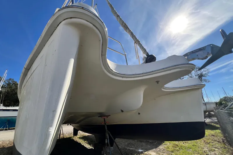 Slide: The Image of 2013 Gemini Legacy 35 catamaran on land, viewed from below, with clear blue sky. - 155