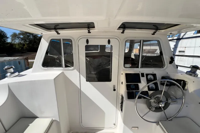 Slide: The Image of Cockpit of 2013 Gemini Legacy 35 sailboat with steering wheel and navigation instruments. - 90