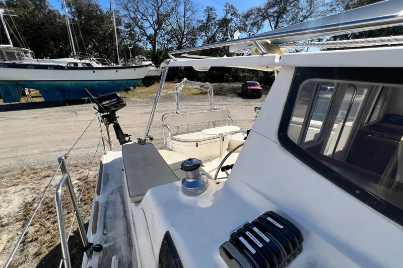 Slide: The Image of 2013 Gemini Legacy 35 sailboat on land, featuring deck and Mercury motor. - 98