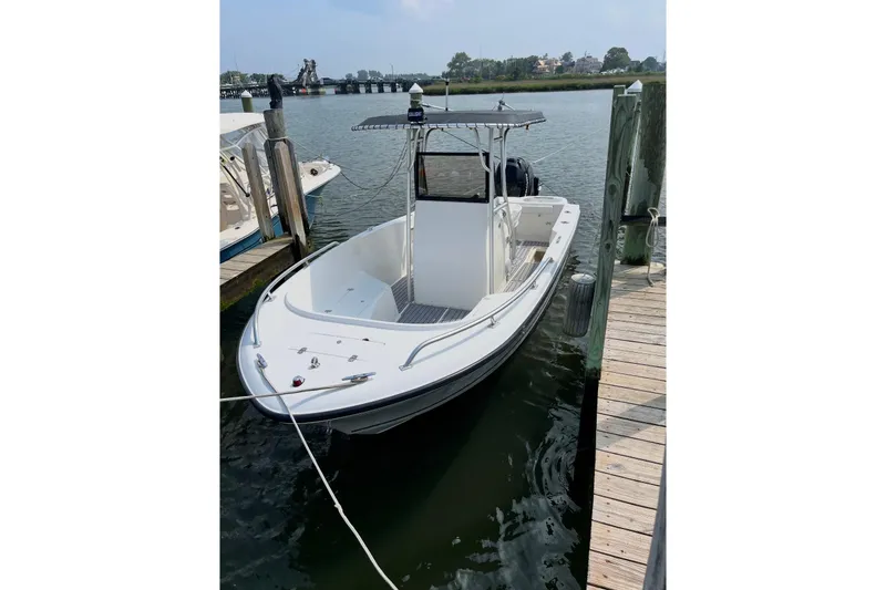 Slide: The Image of 2005 Mako 232 Center Console boat docked at a marina. - 2