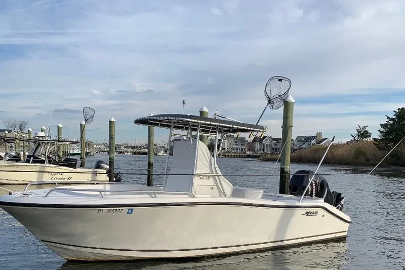 Slide: The Image of 2005 Mako 232 Center Console boat docked in a marina. - 3