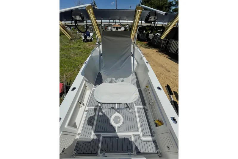 Slide: The Image of 2005 Mako 232 Center Console boat with seating and rod holders, docked outdoors. - 6