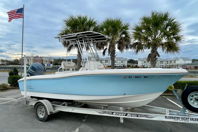 The Image of 2013 Pioneer 197 Sportfish boat on trailer, parked near palm trees and American flag. - 0