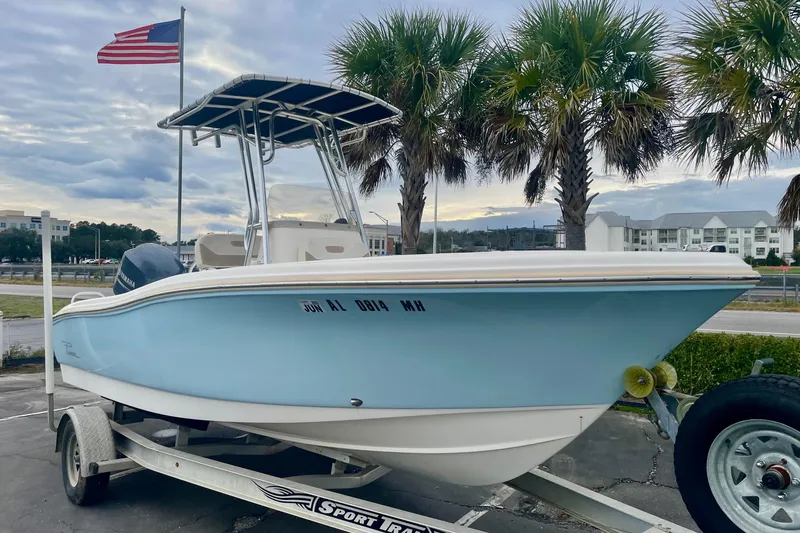 Slide: The Image of 2013 Pioneer 197 Sportfish boat on trailer with palm trees and American flag. - 1