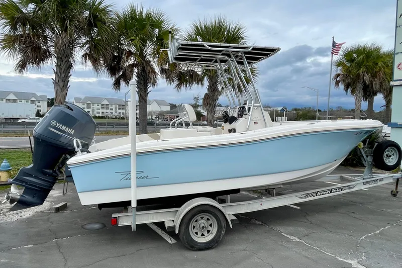 Slide: The Image of 2013 Pioneer 197 Sportfish boat on trailer with Yamaha engine, parked near palm trees. - 4