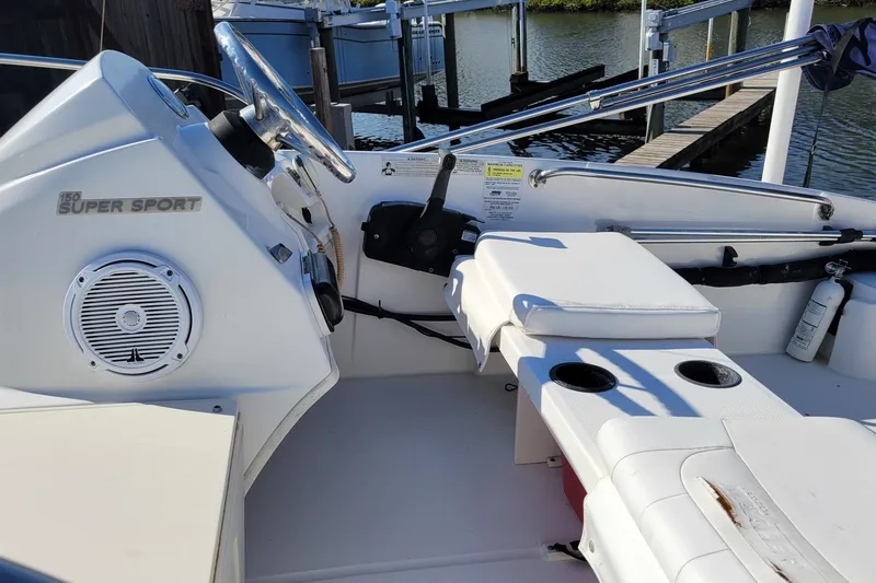 Slide: The Image of 2015 Boston Whaler 150 Super Sport boat interior with steering wheel and seating. - 10