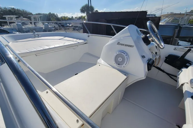 Slide: The Image of 2015 Boston Whaler 150 Super Sport boat interior with steering console and seating. - 11