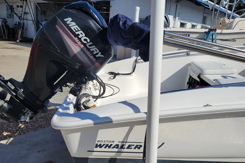 Slide: The Image of 2015 Boston Whaler 150 Super Sport with Mercury outboard motor in a marina setting. - 4