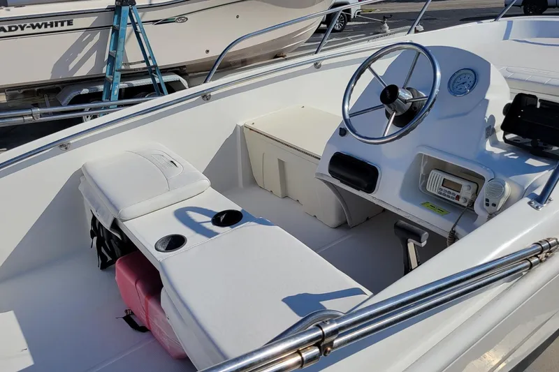 Slide: The Image of 2015 Boston Whaler 150 Super Sport boat interior with steering wheel and seating. - 5