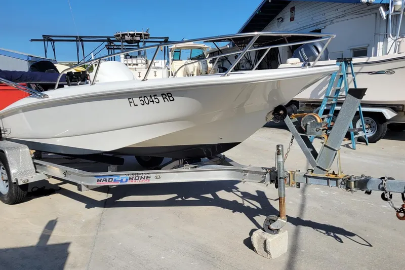 Slide: The Image of 2015 Boston Whaler 150 Super Sport boat on trailer, parked outdoors. - 8