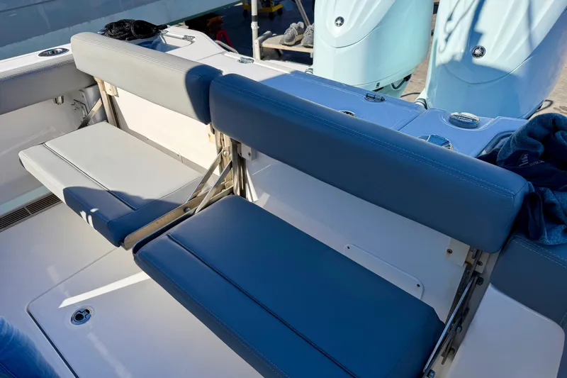 Slide: The Image of 2023 Everglades 285 Center Console boat seating with blue cushions and dual engines. - 11