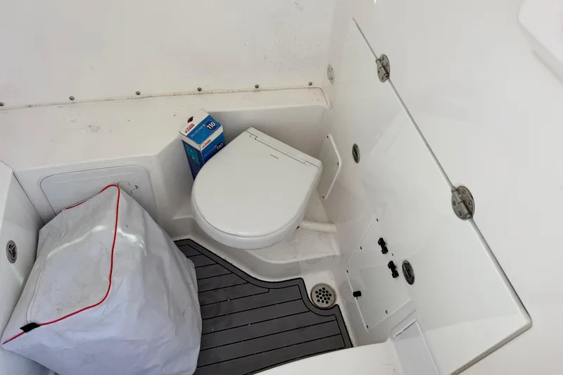 Slide: The Image of 2023 Everglades 285 Center Console boat bathroom with toilet and storage. - 13