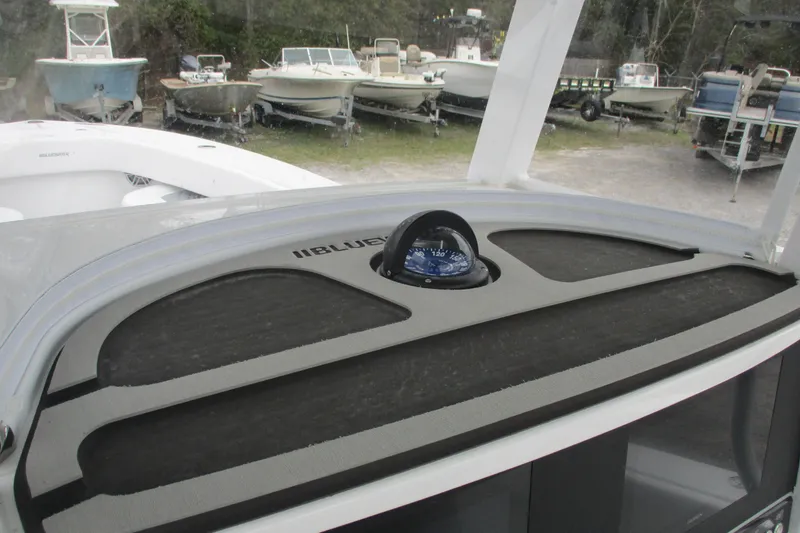 Slide: The Image of 2026 Bluewater 25t boat dashboard with compass, surrounded by other boats. - 16