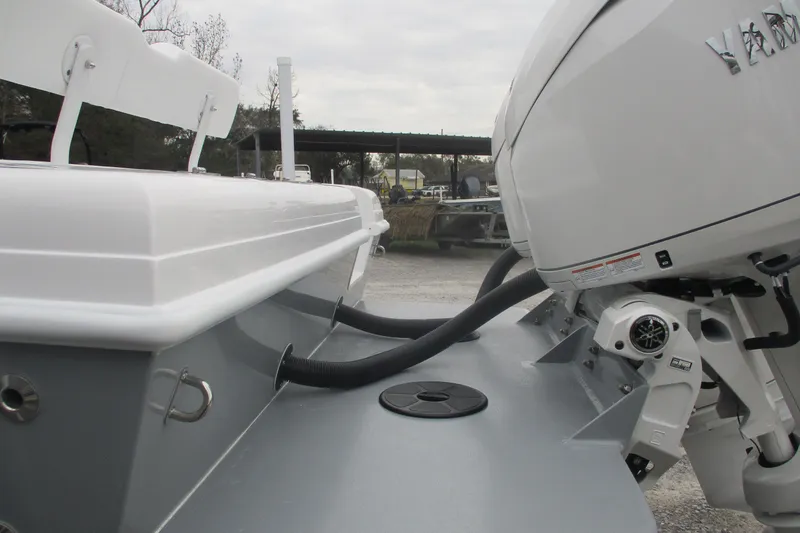 Slide: The Image of 2026 Bluewater 25t boat with outboard motor, rear view, in a marina setting. - 5