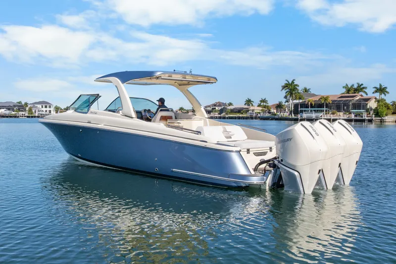The Image of 2021 Chris-Craft Launch 35 GT OB boat on calm water, showcasing sleek design and triple outboard engines. - 0