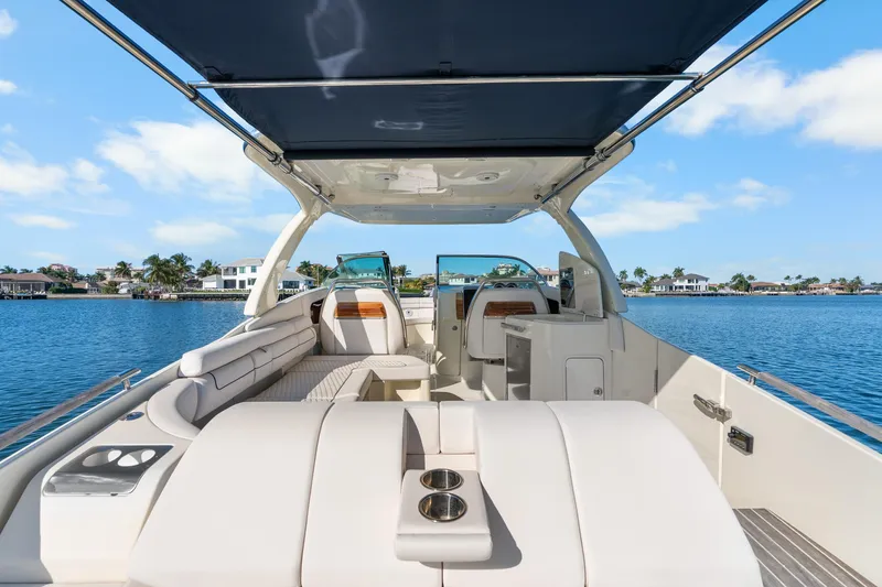 Slide: The Image of 2021 Chris-Craft Launch 35 GT OB boat interior with seating and canopy on a sunny day. - 16