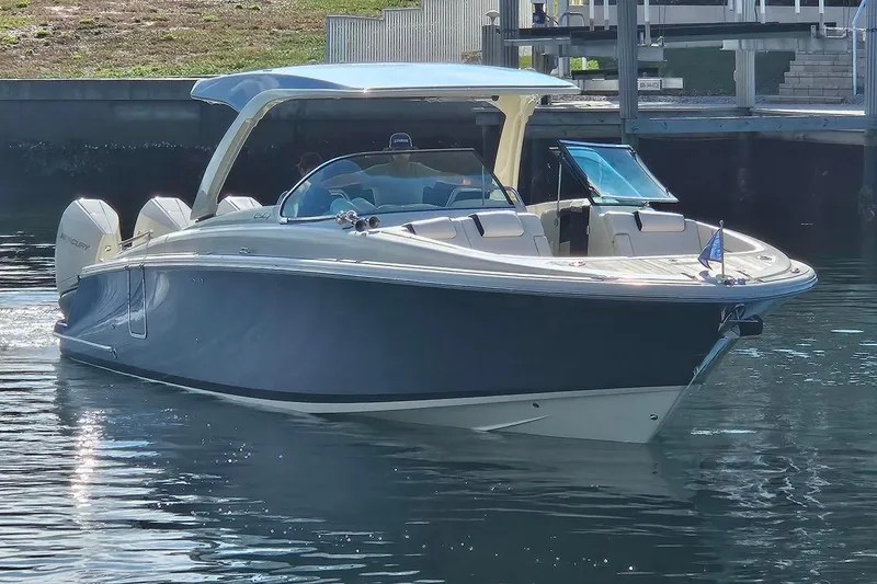 Slide: The Image of 2021 Chris-Craft Launch 35 GT OB boat on calm water, featuring triple Mercury outboard engines. - 2