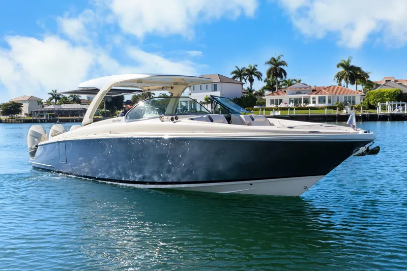 Slide: The Image of 2021 Chris-Craft Launch 35 GT OB boat on serene water, luxury waterfront homes in background. - 9