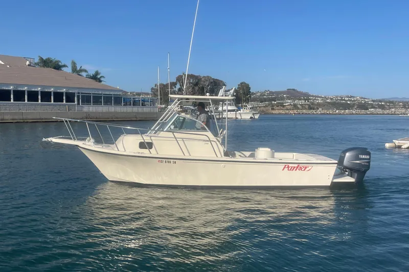 Slide: The Image of 2006 Parker 2310 boat with Yamaha engine on calm water near marina. - 2